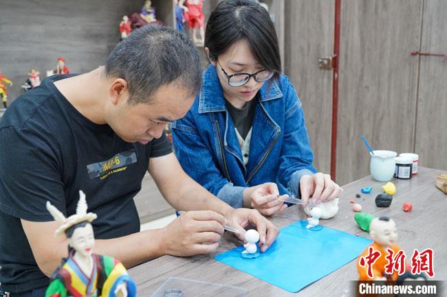 <a target='_blank'  data-cke-saved- >中新社</a>記者(右)現(xiàn)場(chǎng)體驗(yàn)面塑制作過(guò)程?！￡悹?zhēng)強(qiáng) 攝