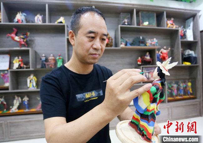 圖為安秋平正在創(chuàng)作代表隴南文縣民俗的《白馬人》作品。　高展 攝