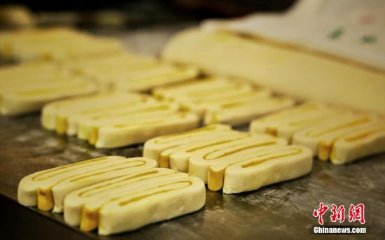 圖為面劑被涂上胡麻油，切成條狀用作月餅的花型制作。張文 攝