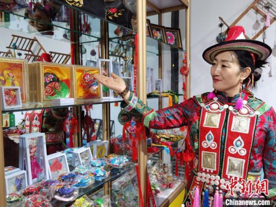 圖為身著民族服飾的隴原巧手展示手工藝品。(資料圖) 徐雪 攝