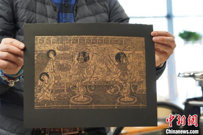 圖為手工書藝人展示敦煌雕版壁畫印刷品?！【琶赖┰?　攝