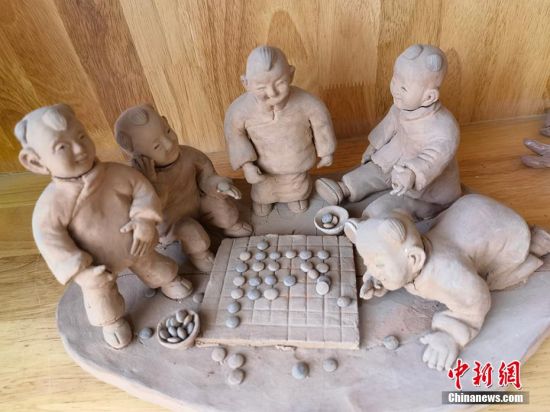 圖為泥塑作品展現(xiàn)下棋場景。 劉玉桃 攝