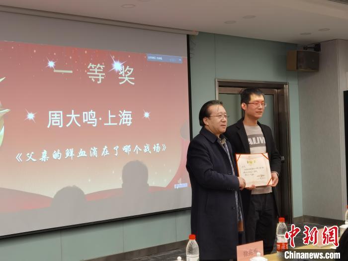 圖為作家、西北師范大學新聞與傳媒學院院長徐兆壽頒發(fā)一等獎證書，代領獎者上臺領獎?！钅?攝