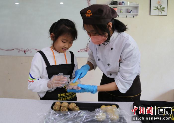 圖為在甘臺胞小朋友在工作人員指導下制作月餅。九美旦增 攝