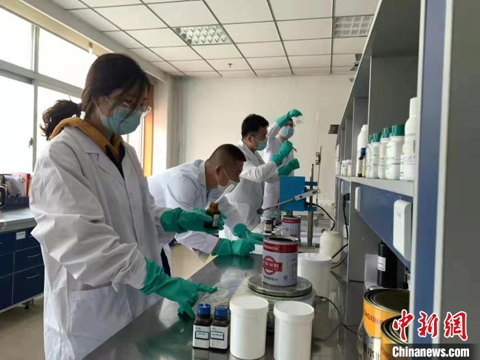 圖為肖菲(前一)帶領團隊研發(fā)水性涂料。(資料圖) 受訪者供圖