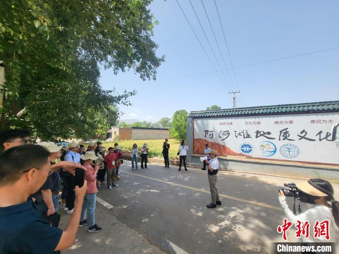 圖為中國(guó)地質(zhì)大學(xué)(北京)教授張緒教介紹村落情況。　胡友軍 攝