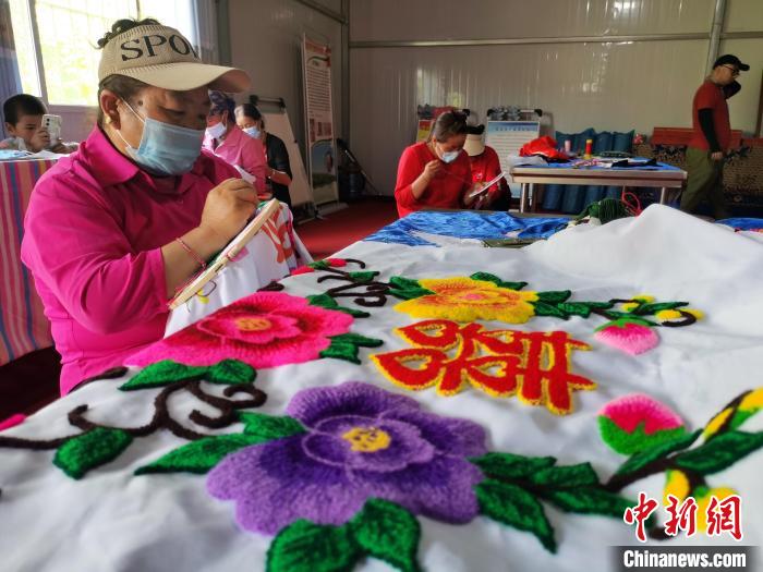 圖為婦女制作青繡?！?zhí)砀?攝