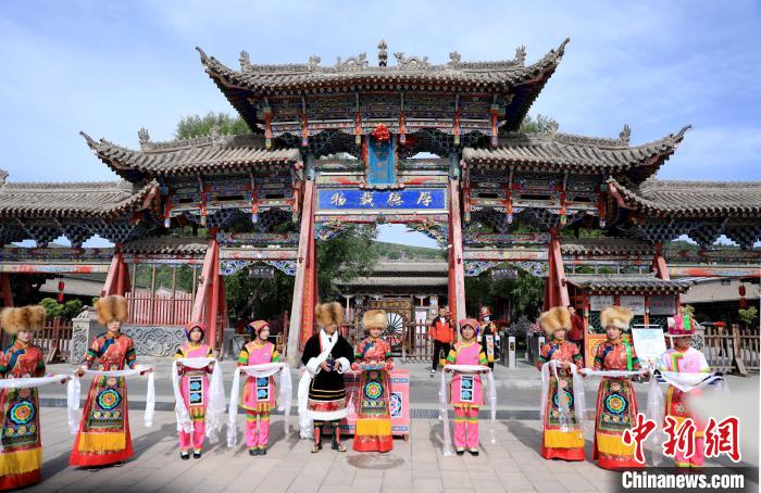 圖為身穿土族服飾的工作人員迎接訪客?！⊙Φ?攝