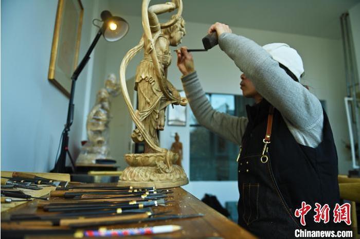 圖為季茂杰進(jìn)行敦煌元素的木雕創(chuàng)作。李亞龍 攝</p>
<p>