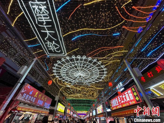 圖為明清街夜市燈光點(diǎn)亮具有武威文化元素的“摩天輪”彩燈?！〈魑牟?攝</p><p>