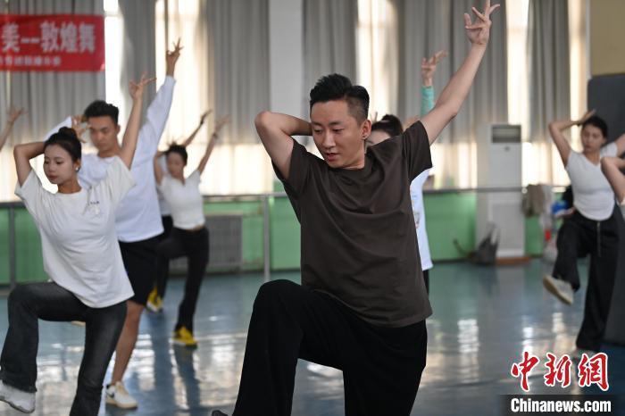 6月6日，在甘肅敦煌青年夜校課程中，青年學(xué)員學(xué)習(xí)敦煌舞課程。李亞龍 攝　　