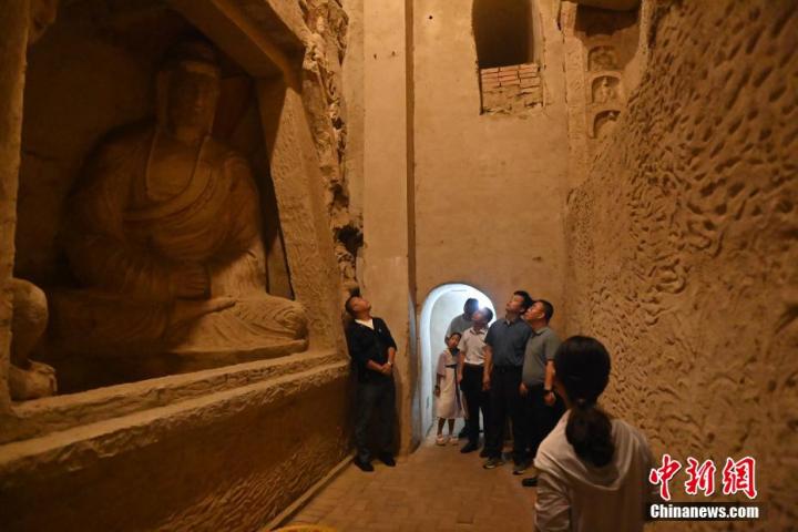 7月15日，游人參觀(guān)甘肅省平?jīng)鍪袥艽h百里石窟長(zhǎng)廊中的王母宮石窟。百里石窟長(zhǎng)廊位于涇川縣境內(nèi)，由512個(gè)石窟、5眼窟中石井組成，現(xiàn)存王母宮石窟、鳳凰山石窟、南石窟寺、丈八寺石窟、羅漢洞石窟、太山寺石窟等規(guī)模較大的石窟群，還有數(shù)量眾多的小石窟群。王母宮石窟又名千佛洞，該窟設(shè)計(jì)宏大，造像生動(dòng)，窟內(nèi)擁有造像數(shù)百尊，是較為珍貴的佛教文化歷史遺存。中新社記者 李亞龍 攝</p>
<p>