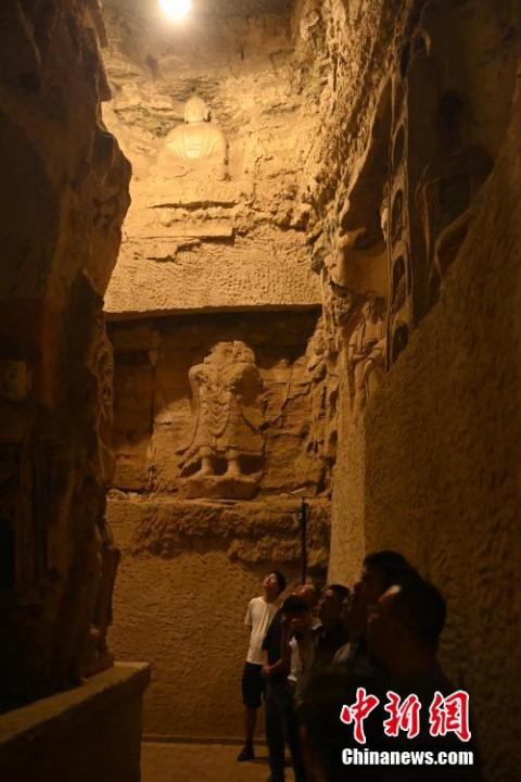 7月15日，游人參觀(guān)甘肅省平?jīng)鍪袥艽h百里石窟長(zhǎng)廊中的王母宮石窟。百里石窟長(zhǎng)廊位于涇川縣境內(nèi)，由512個(gè)石窟、5眼窟中石井組成，現(xiàn)存王母宮石窟、鳳凰山石窟、南石窟寺、丈八寺石窟、羅漢洞石窟、太山寺石窟等規(guī)模較大的石窟群，還有數(shù)量眾多的小石窟群。王母宮石窟又名千佛洞，該窟設(shè)計(jì)宏大，造像生動(dòng)，窟內(nèi)擁有造像數(shù)百尊，是較為珍貴的佛教文化遺存。中新社記者 李亞龍 攝</p>
<p>